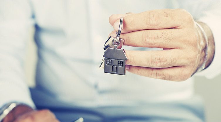 Un homme tenant les clés de son appartement dans sa main